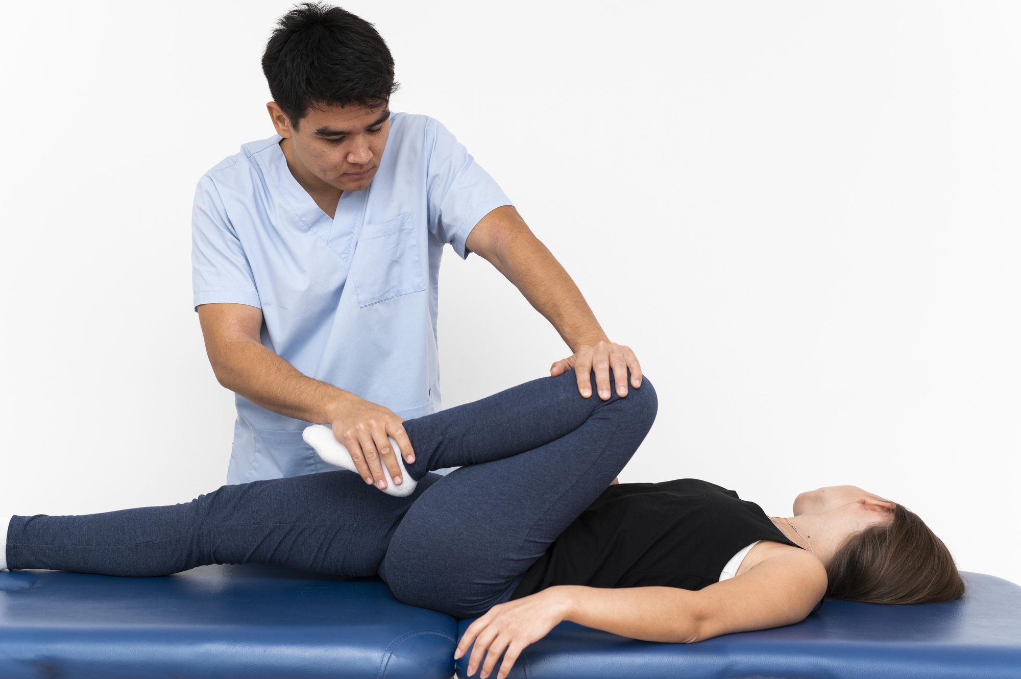 physiotherapist-doing-leg-exercises-with-female-patient